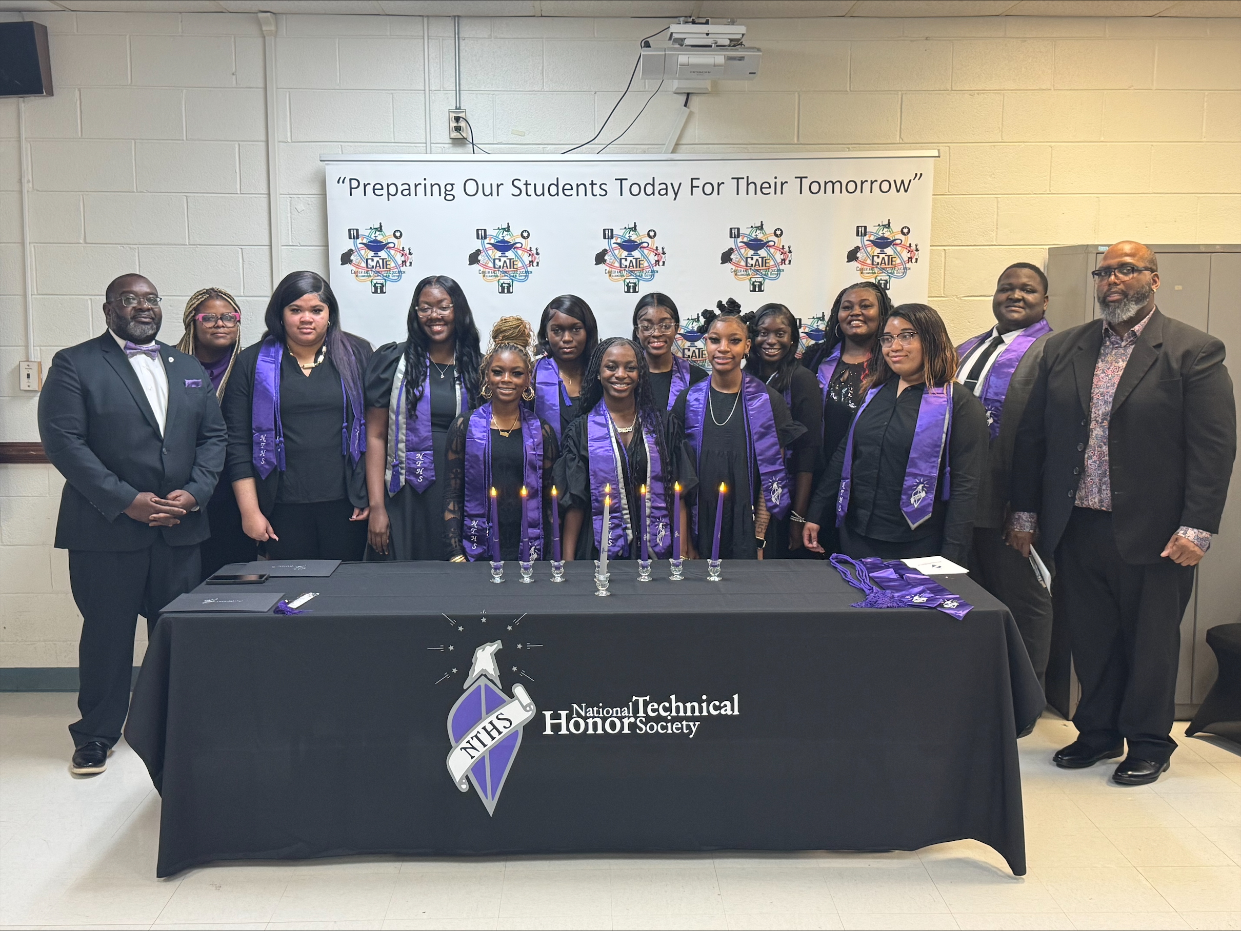 "Preparing Our Students Today for Their Tomorrow" students standing along with two instructors in front of table with NTHS covering 