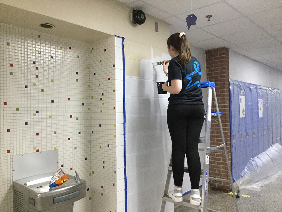 Students volunteering to help paint