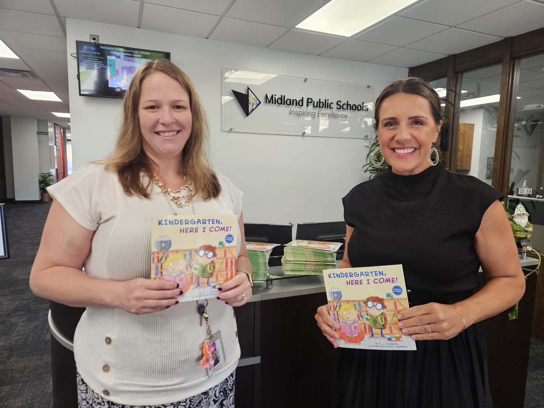 GSC Director Bethany Shoun and Associate Superintendent Kara Stark stand holding copies of the free books