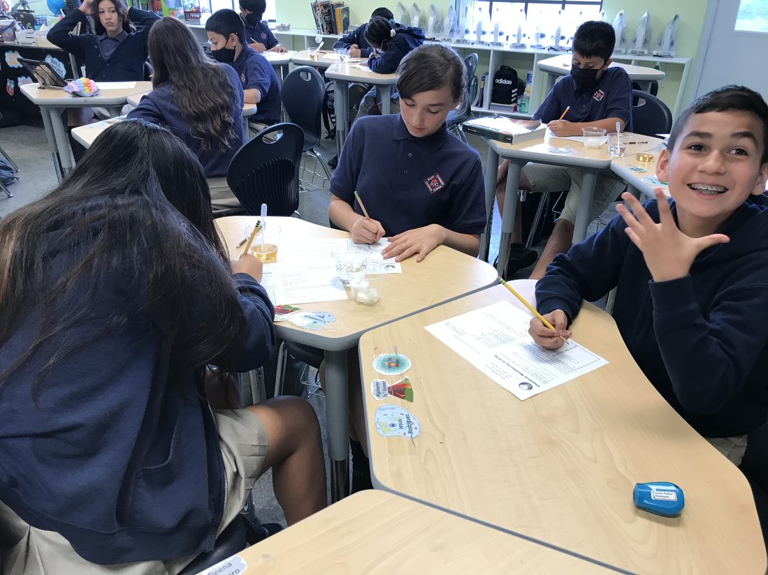 Jesus, Kiristamarie, and Zuleyma record their observations as their sugar cubes erode.