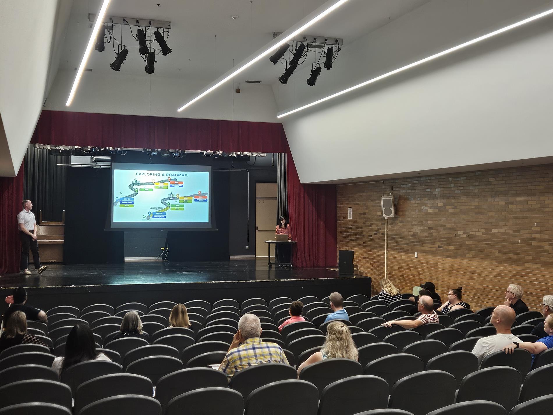 Attendees sit for the 2nd session watching the presentation on the stage in the Little Theater