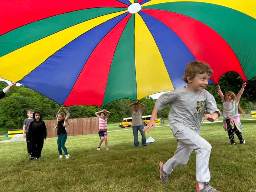 Student running under a parachute.