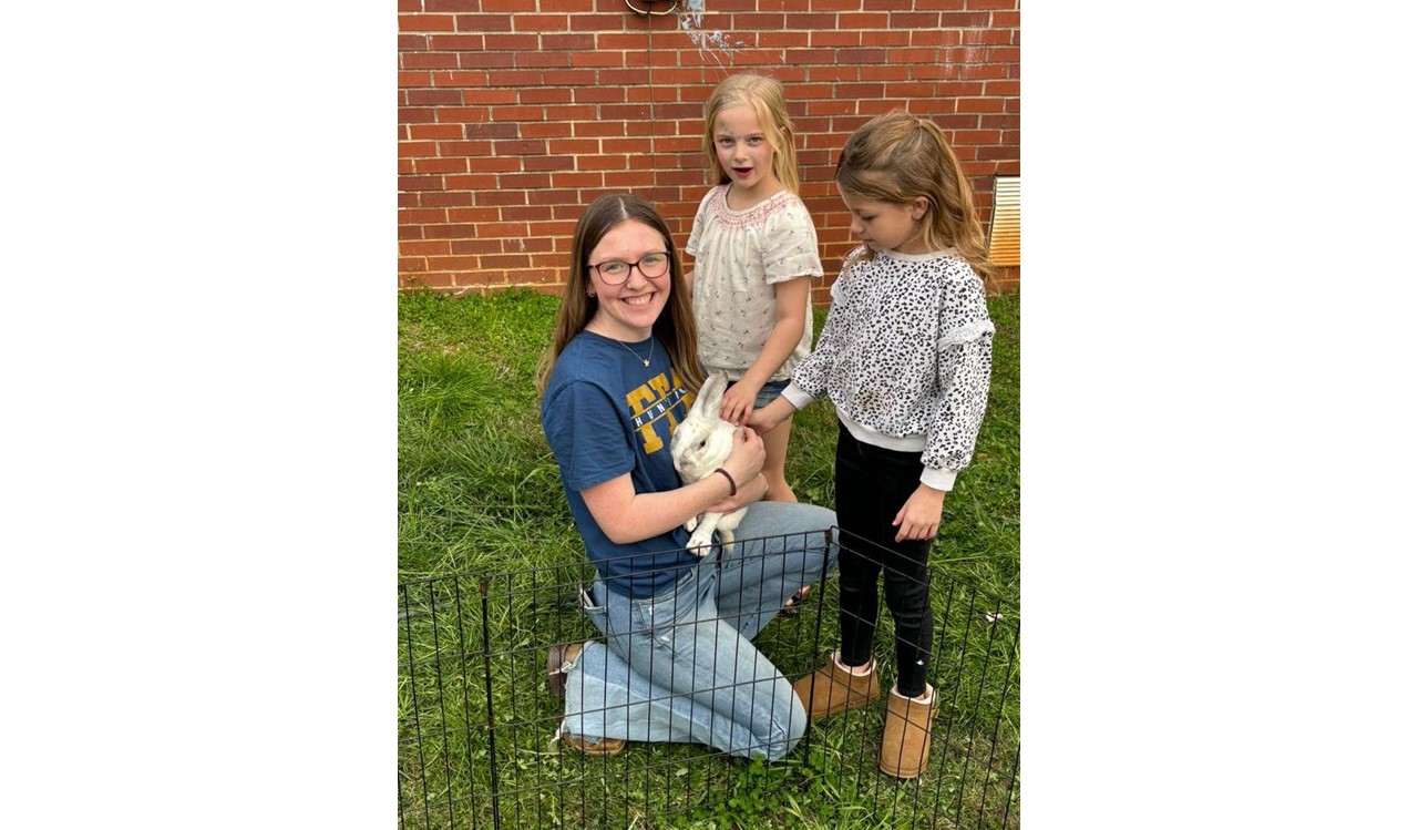 Morgan Pogue is pictured with elementary students at the petting zoo during the Spring Fling.