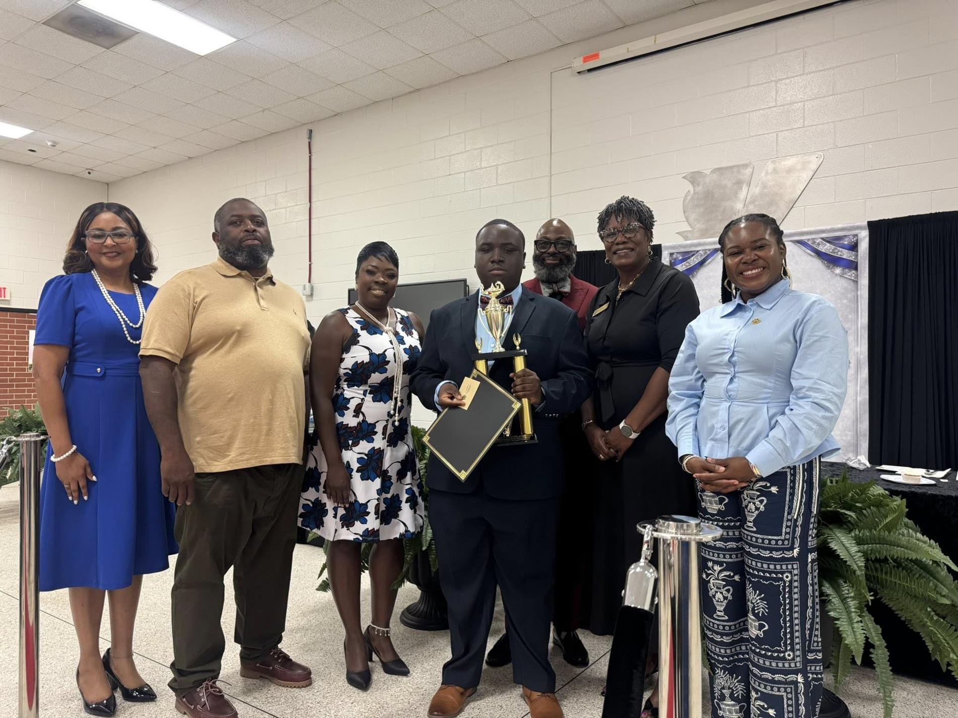 people standing together. one is receiving an award 
