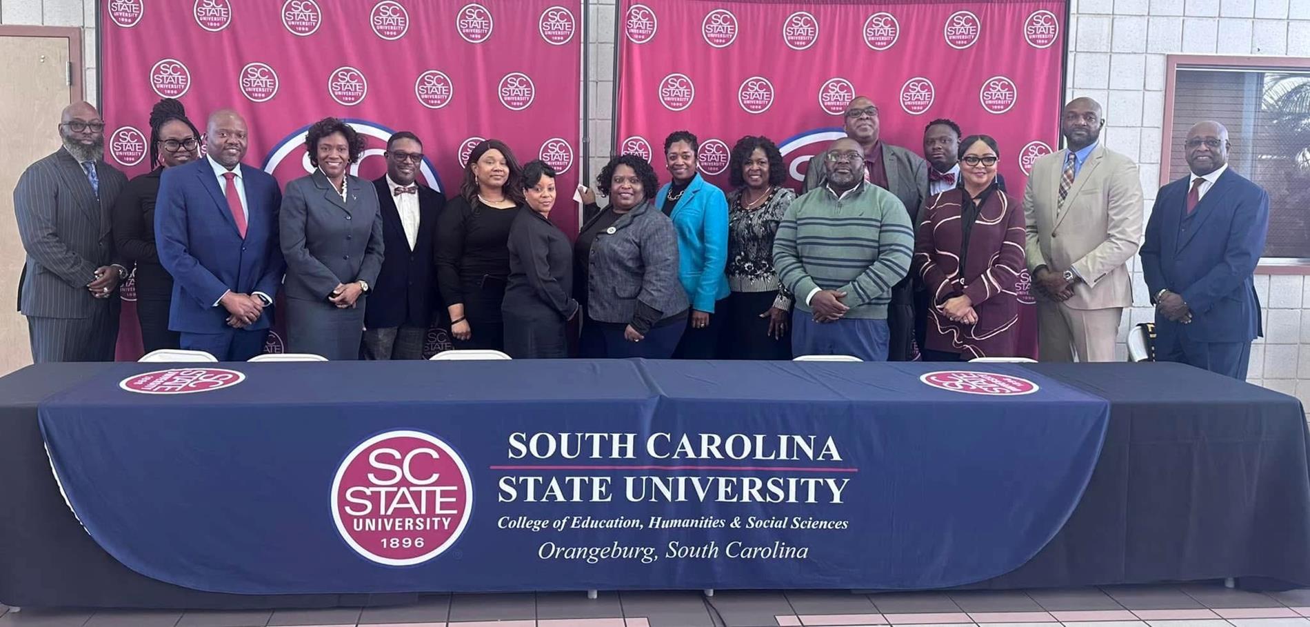 SC State University 1896 South Carolina State University College of Education, Humanities & Social Sciences Orangeburg, South Carolina. Picture of adults standing behind a table