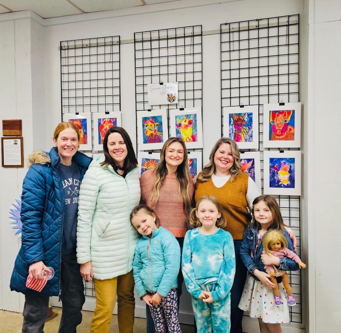 adults and students with artwork display