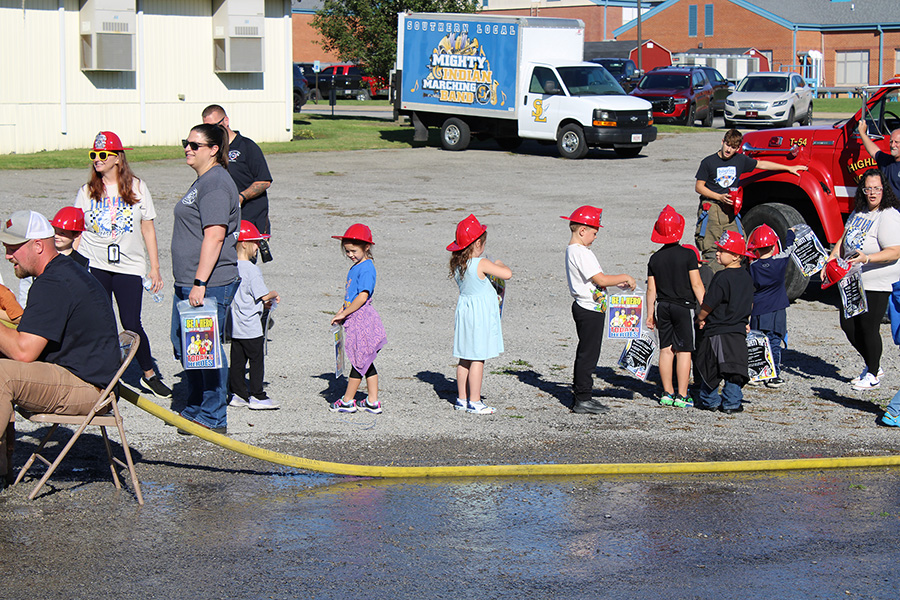 Students see the equipment on the trucks and get their own fire helmet