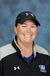 Teacher smiling against a blue background