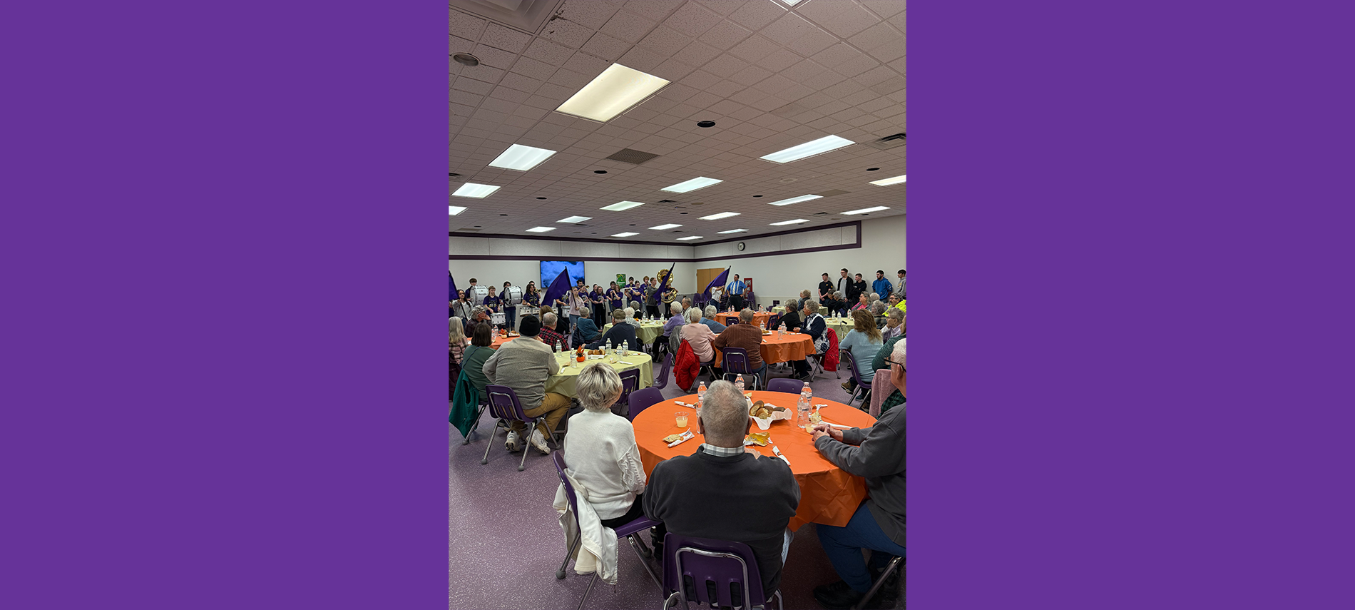 Thanksgiving Community Dinner, community members listening to the high school band will sitting around tables