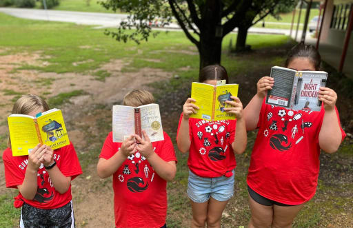 4 kids reading at camp