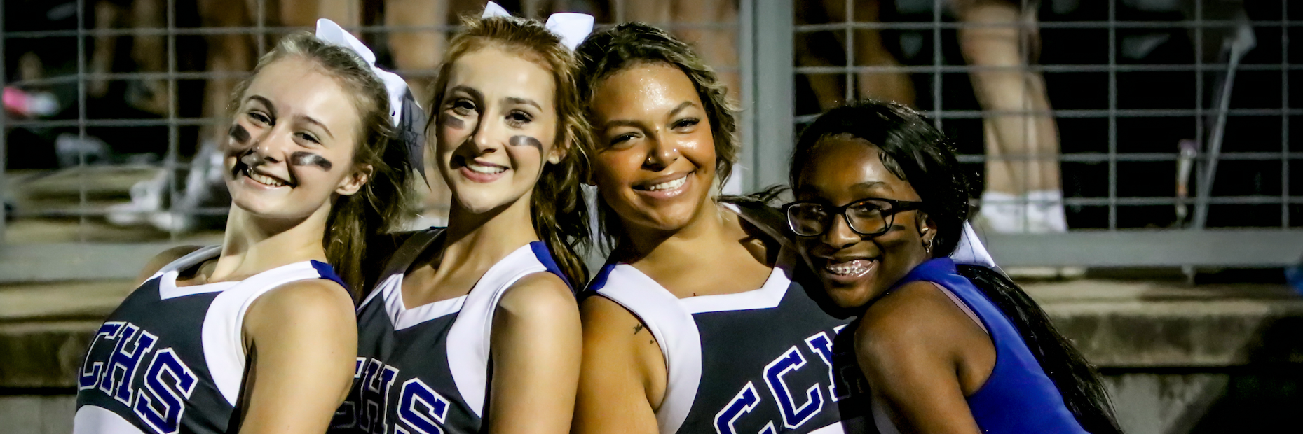 Cheerleaders pose for photo at football game