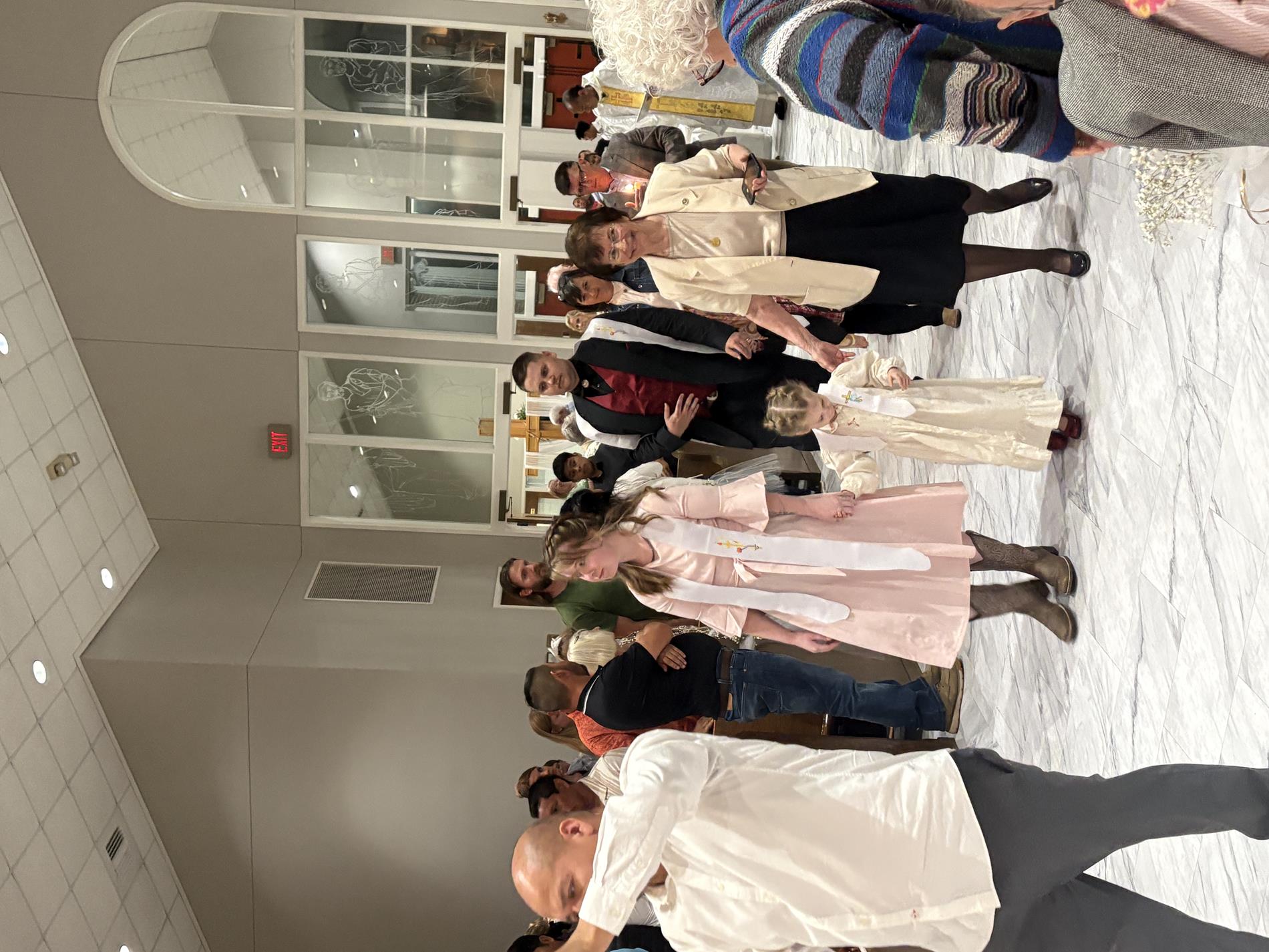 New Catholics process to the front of the church