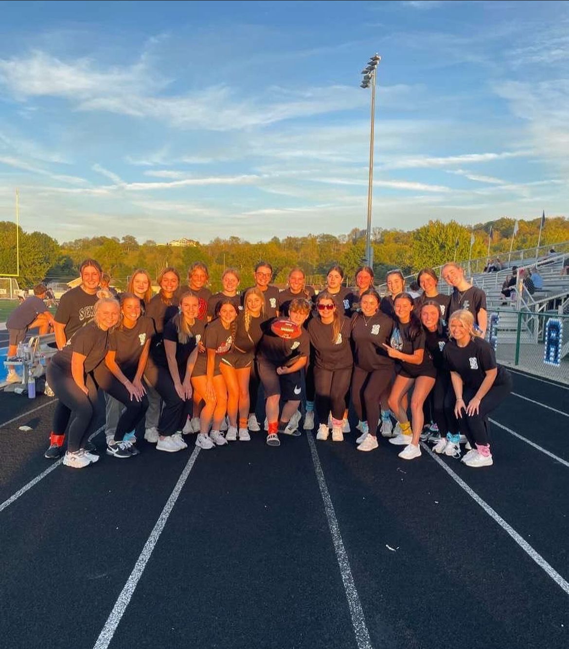 12th grade students during homecoming week standing at the track smiling