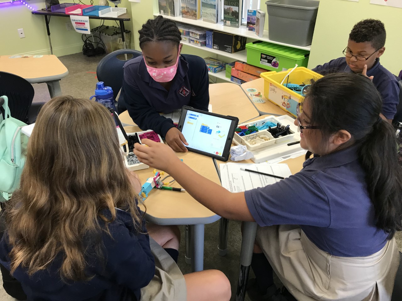 Ella, Allanah, Valeria, and Maison collaborate to improve their prosthetic prototype. 