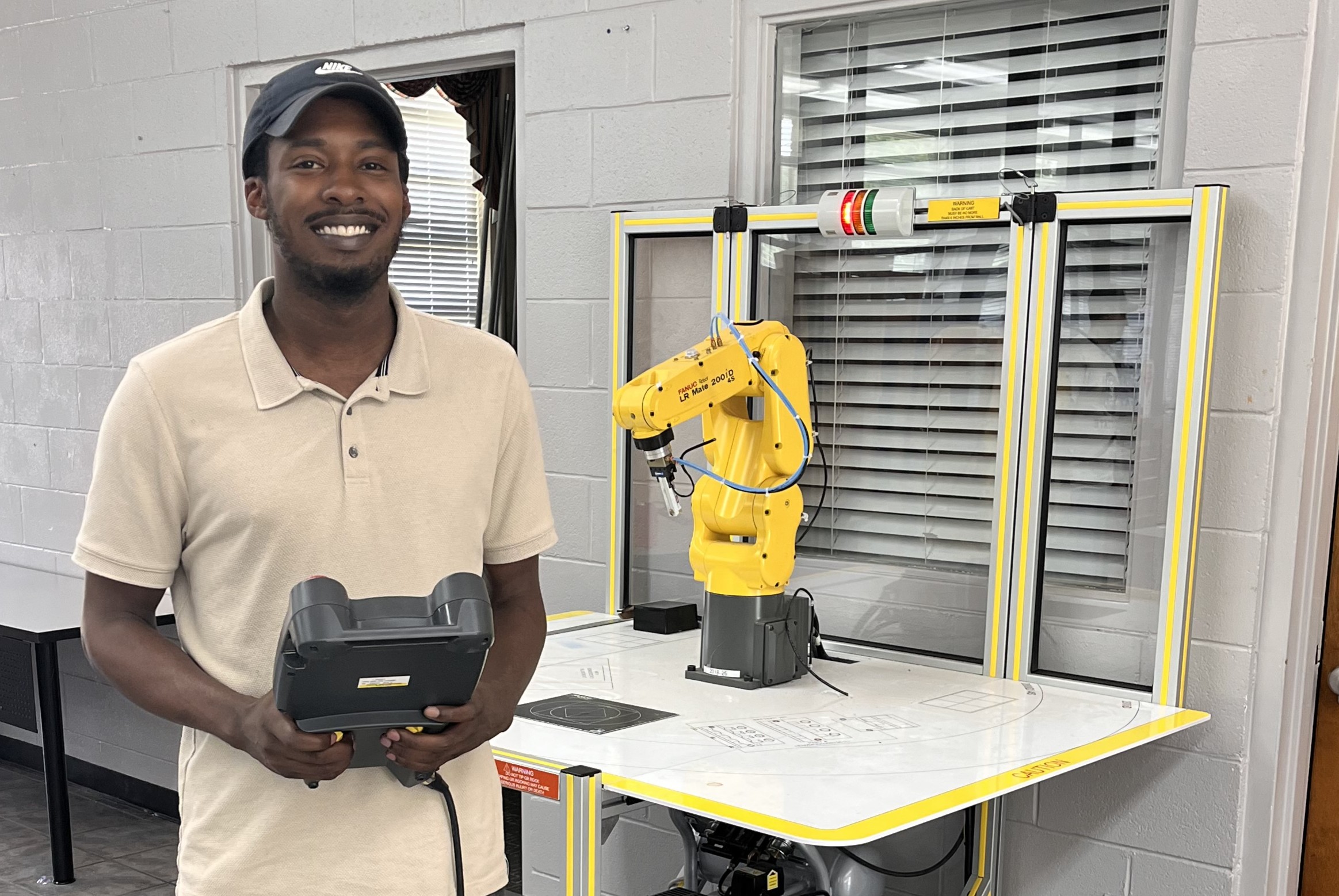 Reid State Student Spencer Stallworth Stands in Front of a Robotic Arm