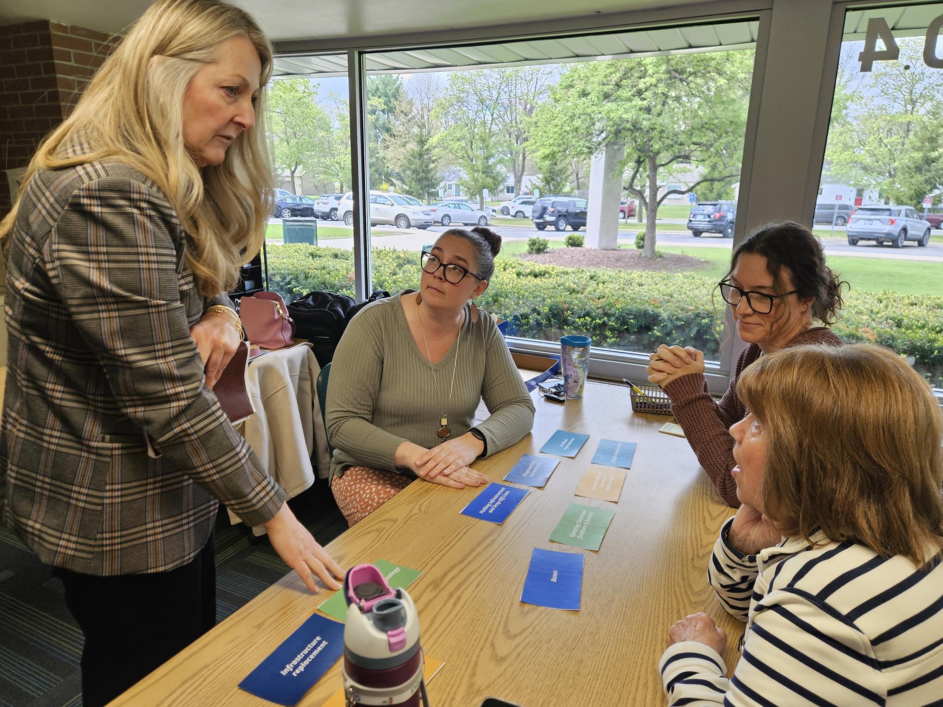 Superintendent Penny Miller-Nelson chats with a small group of community members about their selections
