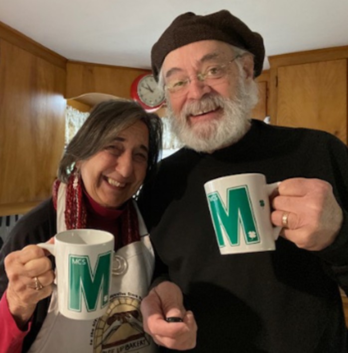 Two adults holding coffee mugs