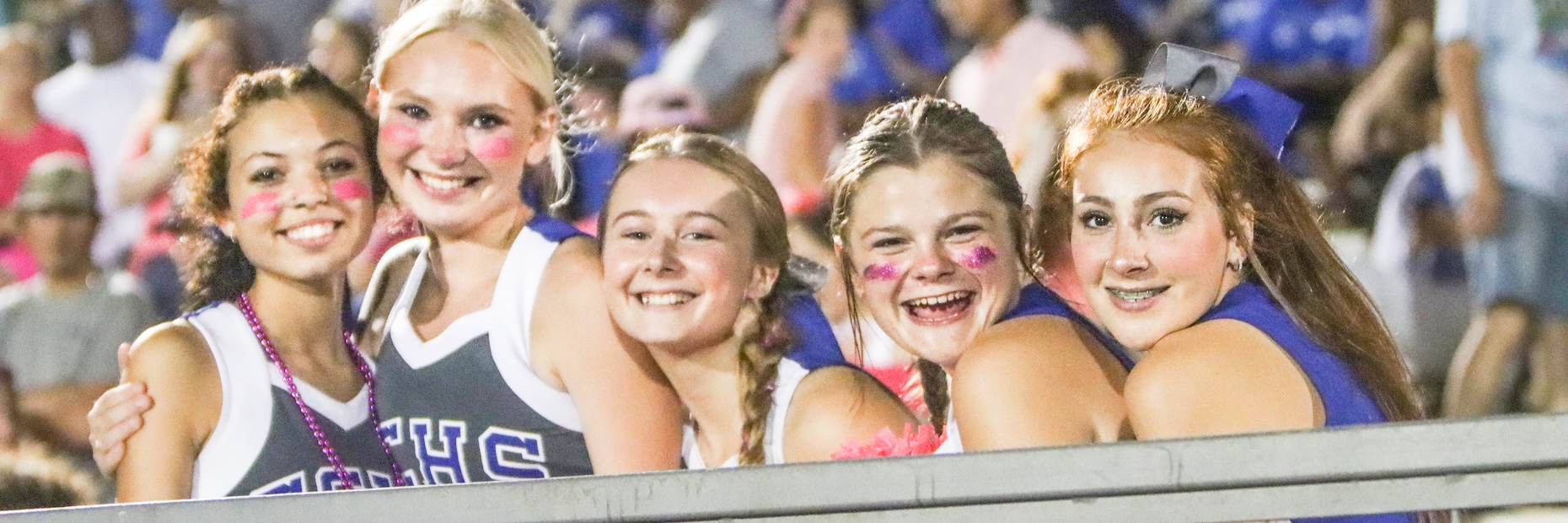 Cheerleaders pose for photo at football game