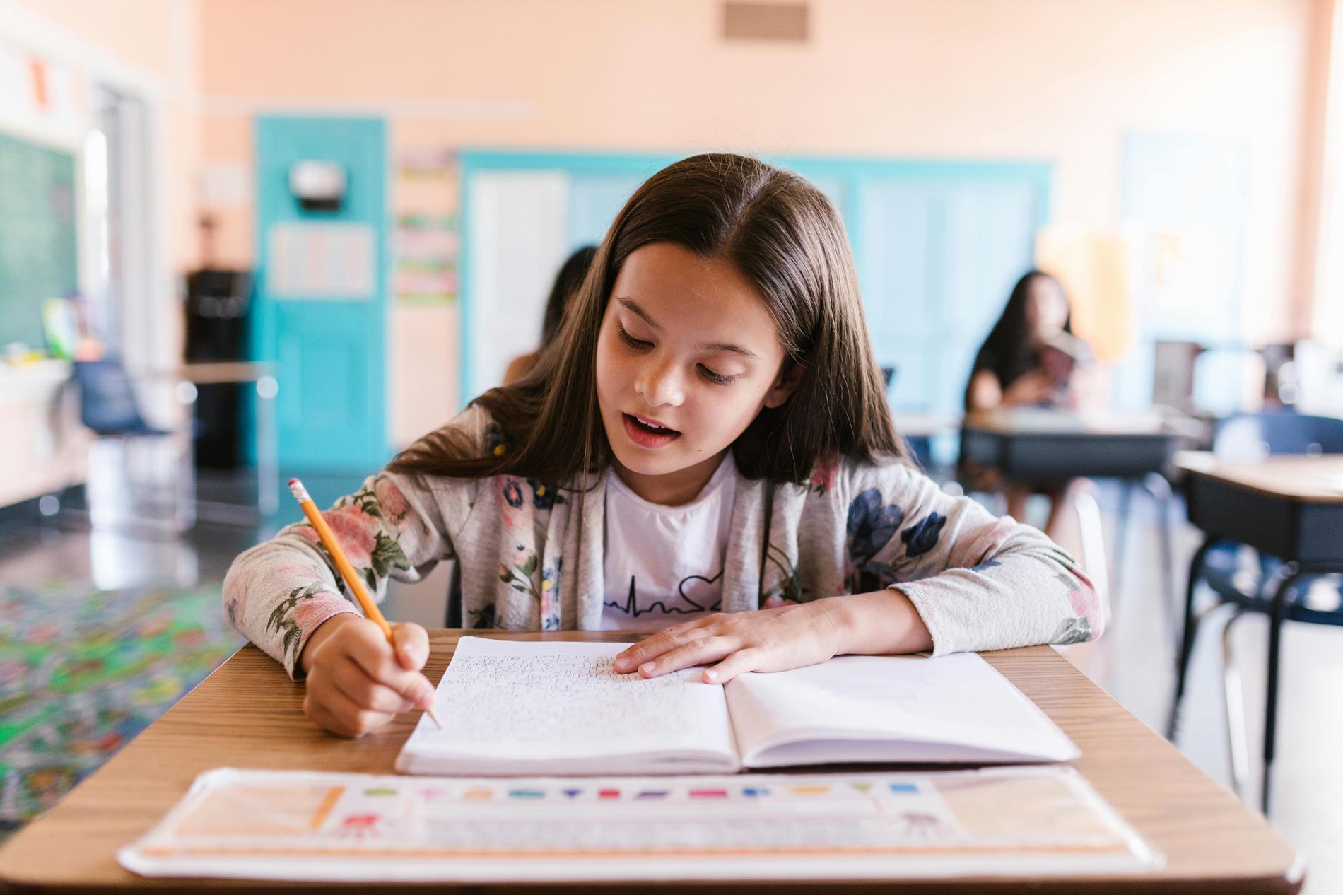 child sitting at a desk doing homework for elementary school