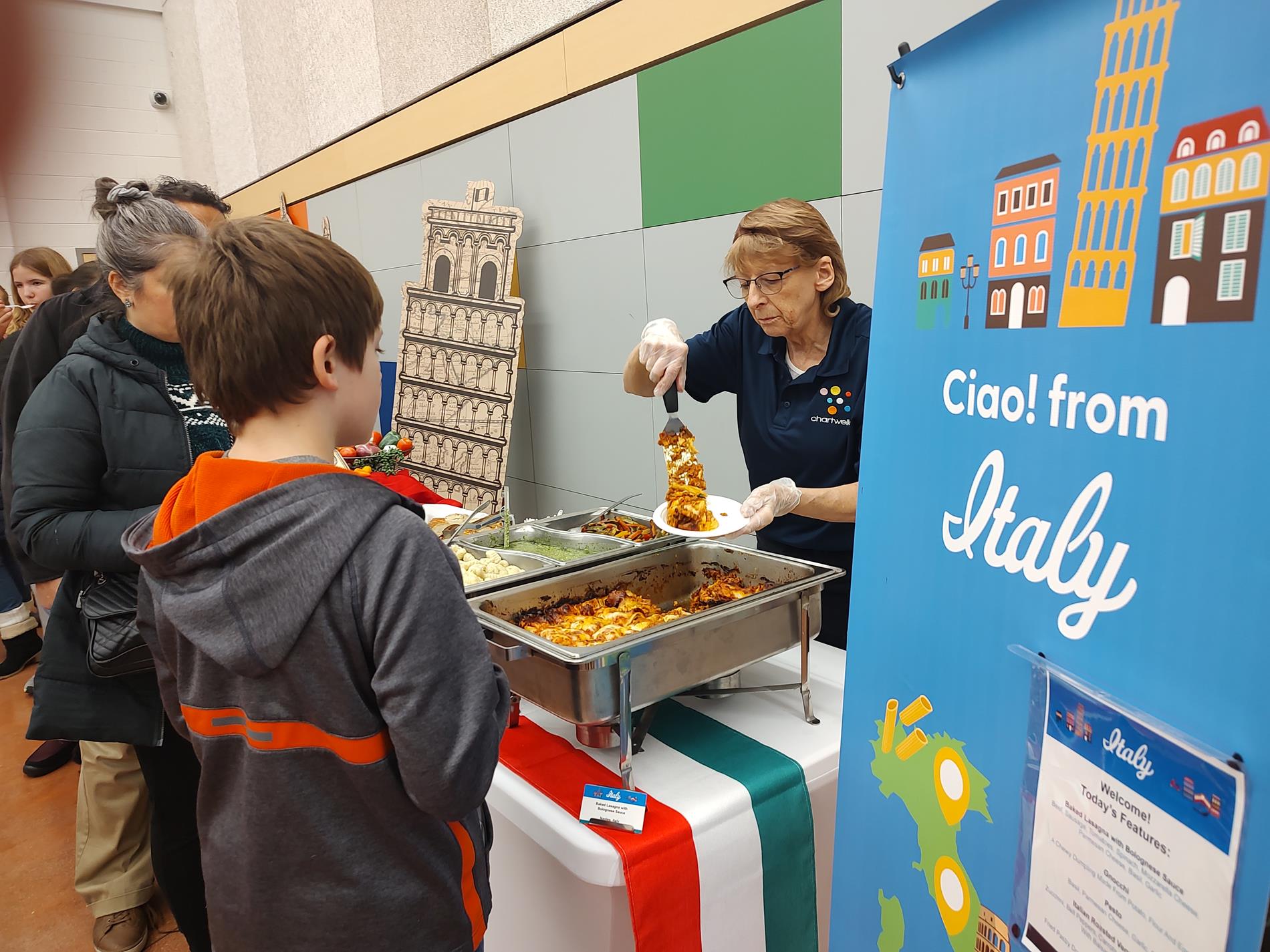 Food service working serving italian food at taste of the world event