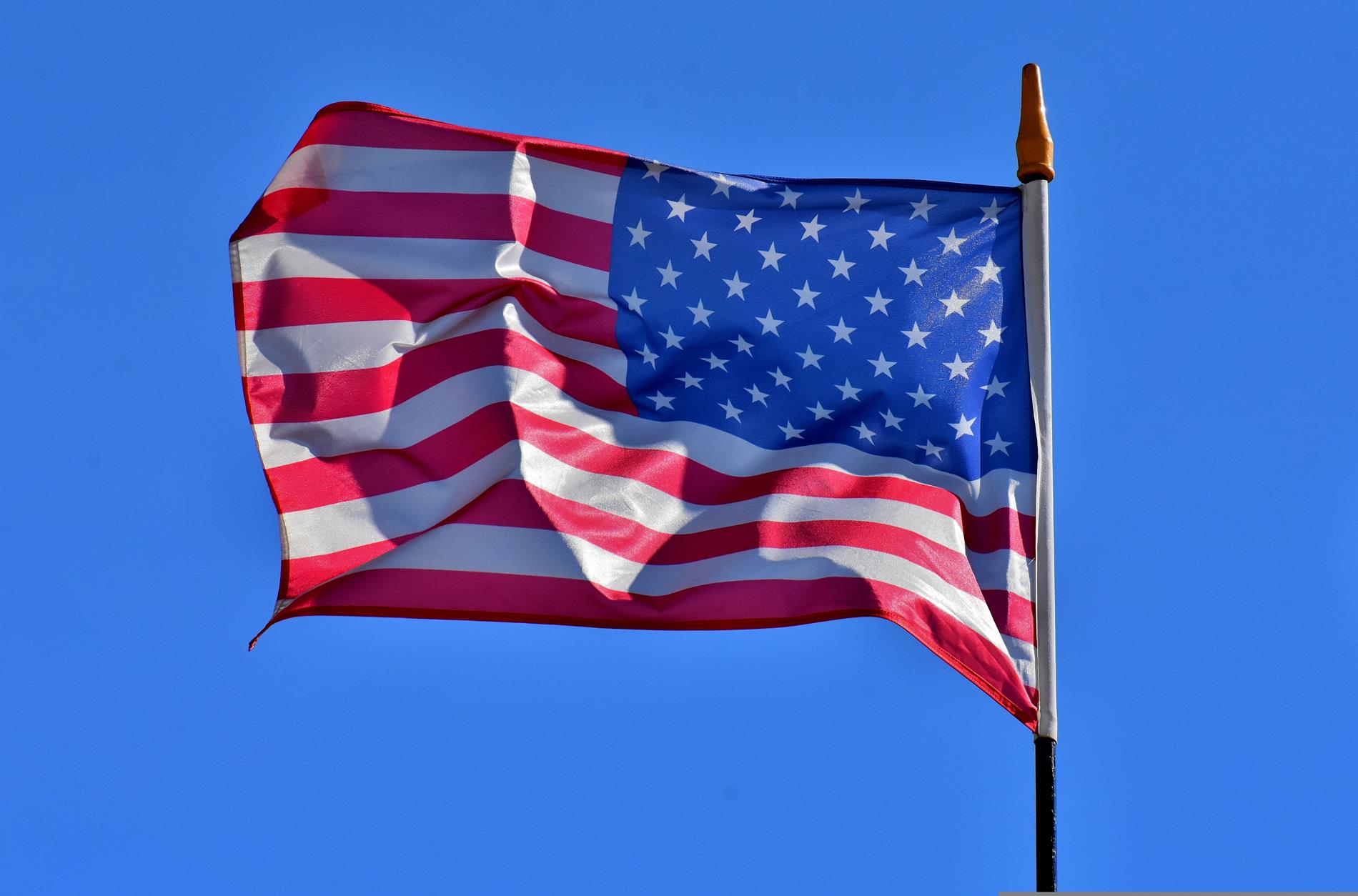An American flag flies against a blue sky