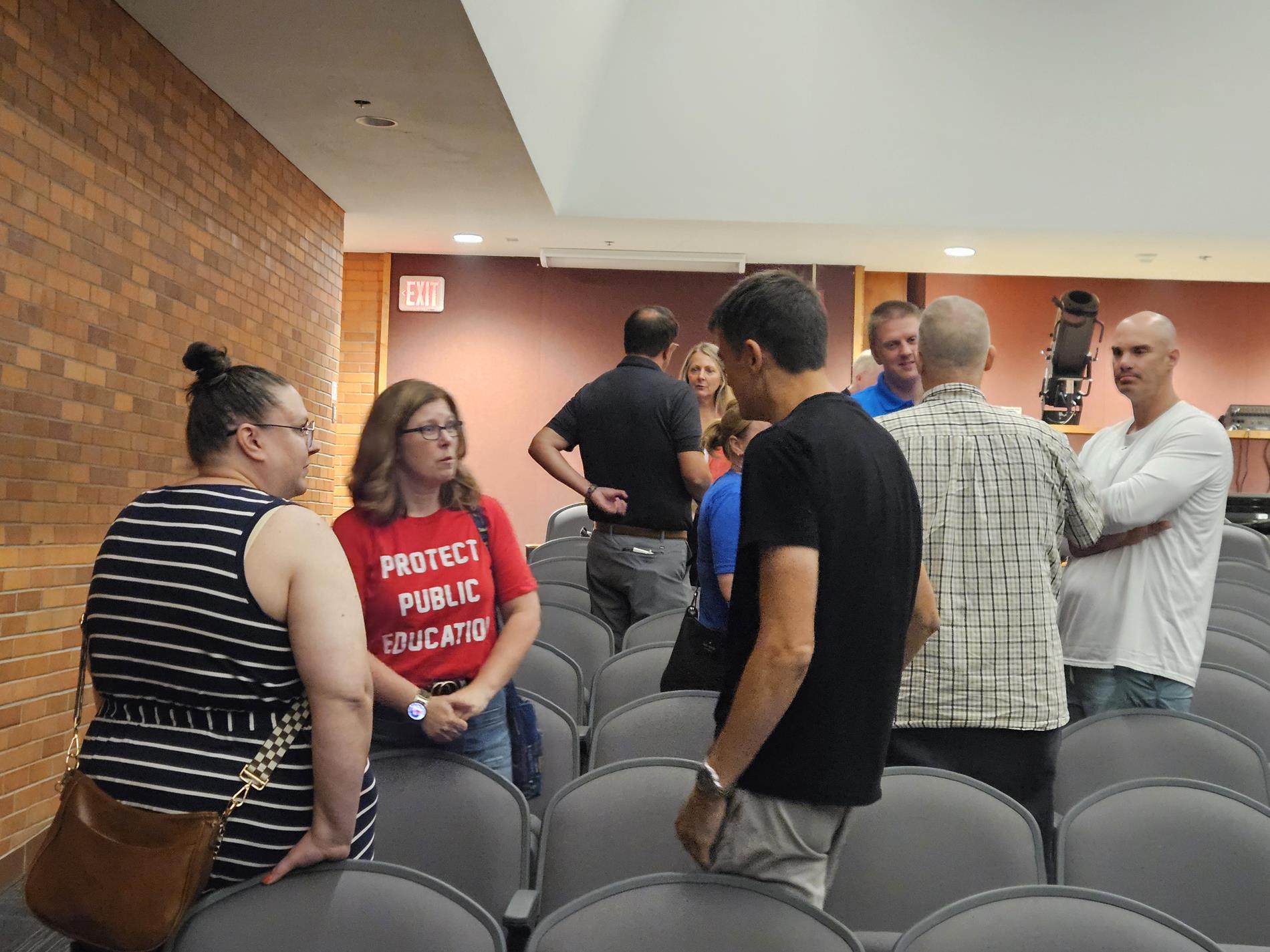 Groups of attendees mingle after the presentation to talk about their thoughts