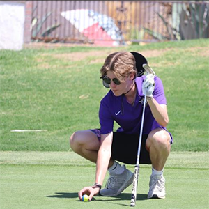 Boys Golf team member setting up a putt
