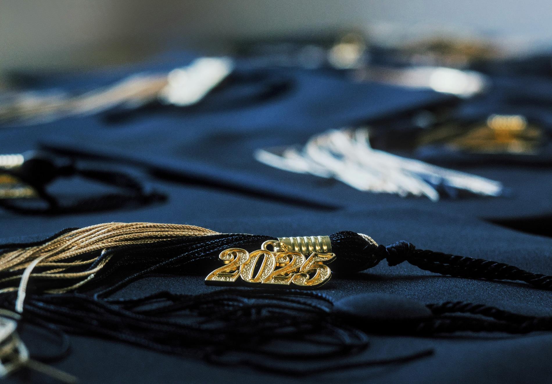 A graduation tassle with a gold 2025 on it sits on a table