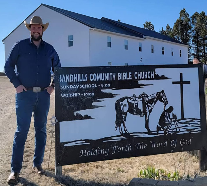 Seth Hower, standing in front of Sandhills Community Bible Churh