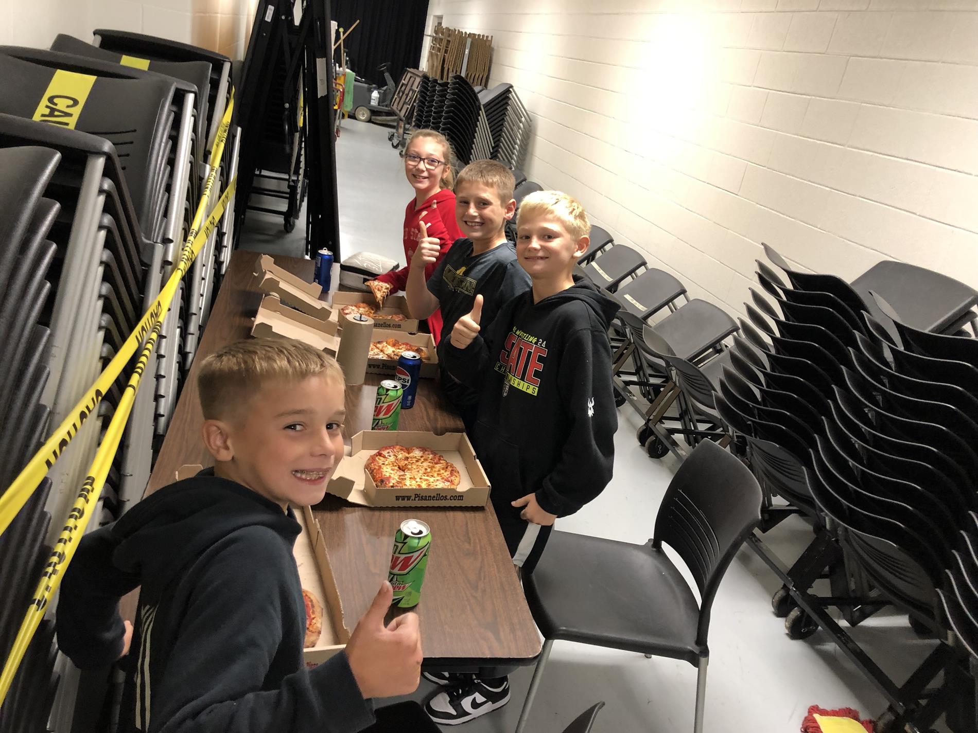 4th graders who help in the cafeteria eating pizza