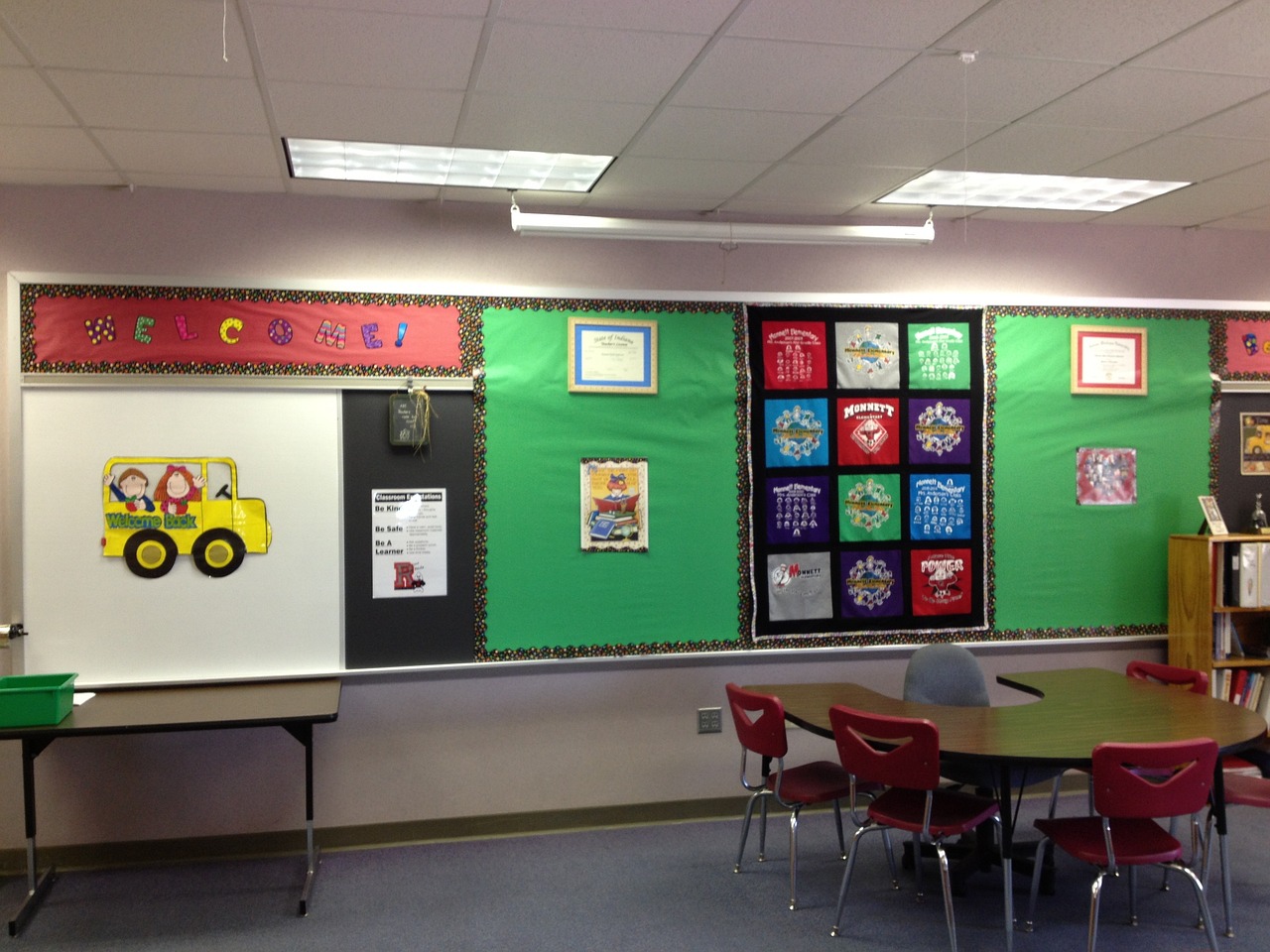 classroom with table and chairs and posters on the wall