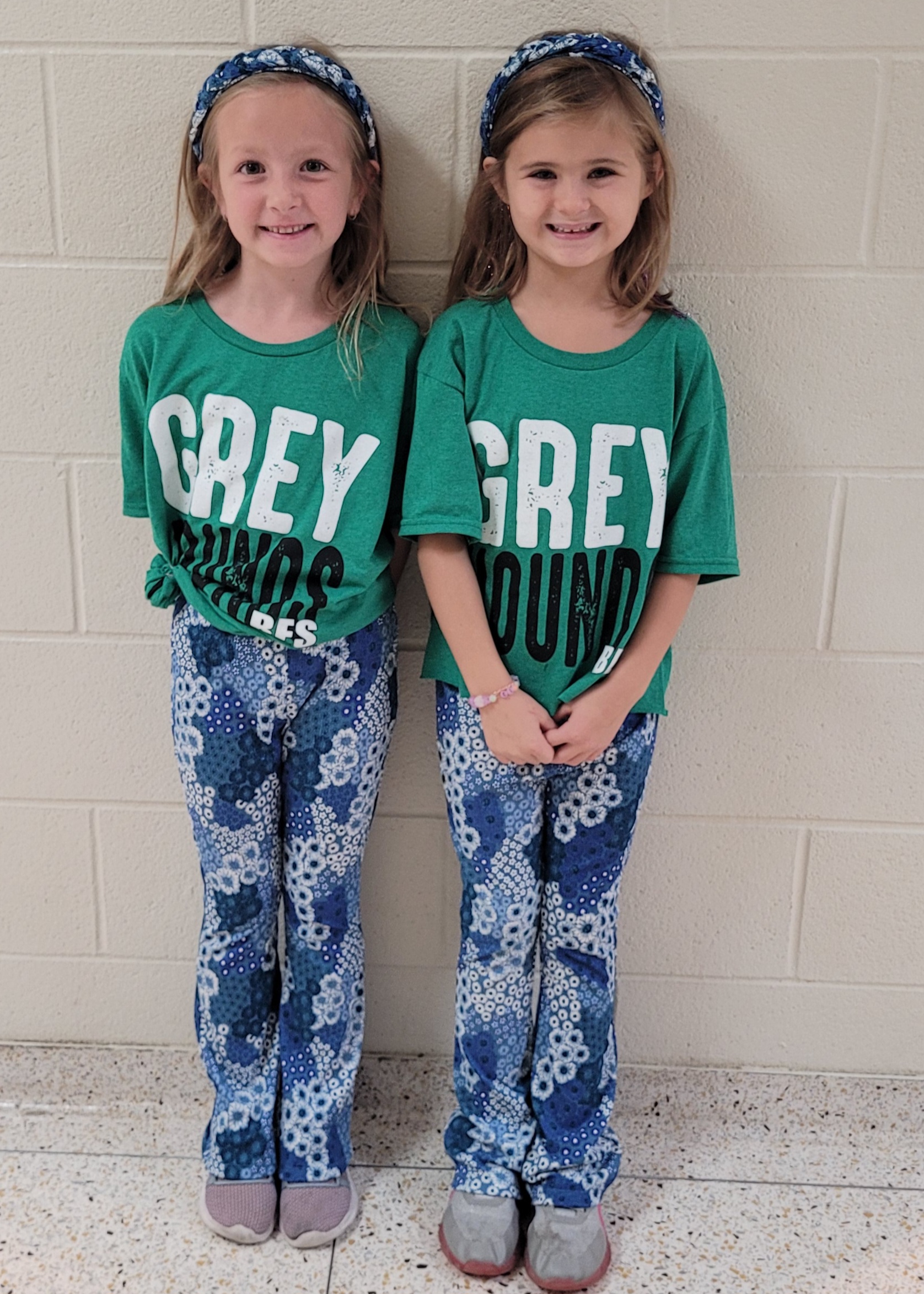 two little girls matching for twin day with their greyhound gear. 