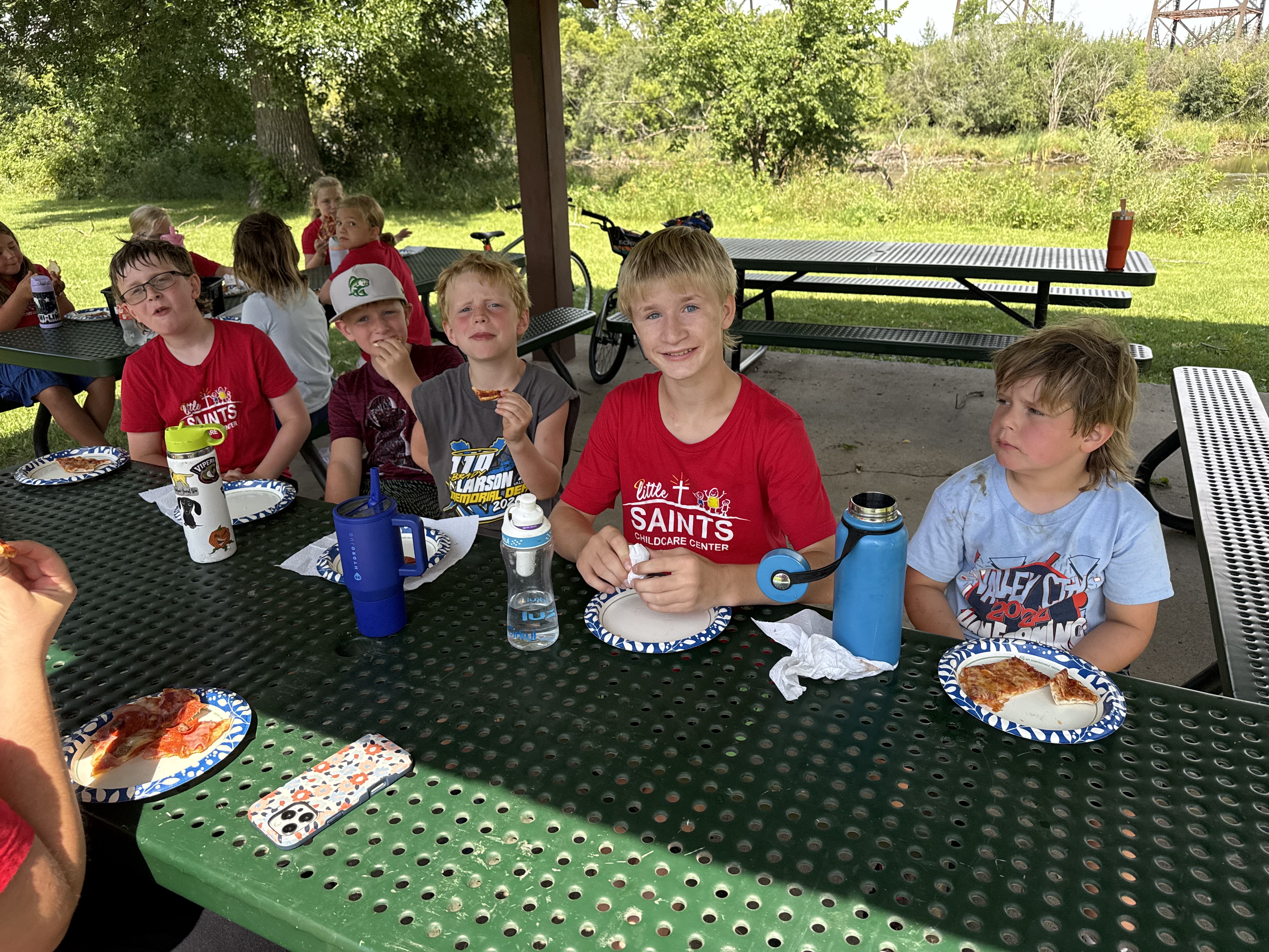 children smiling at a picnic table