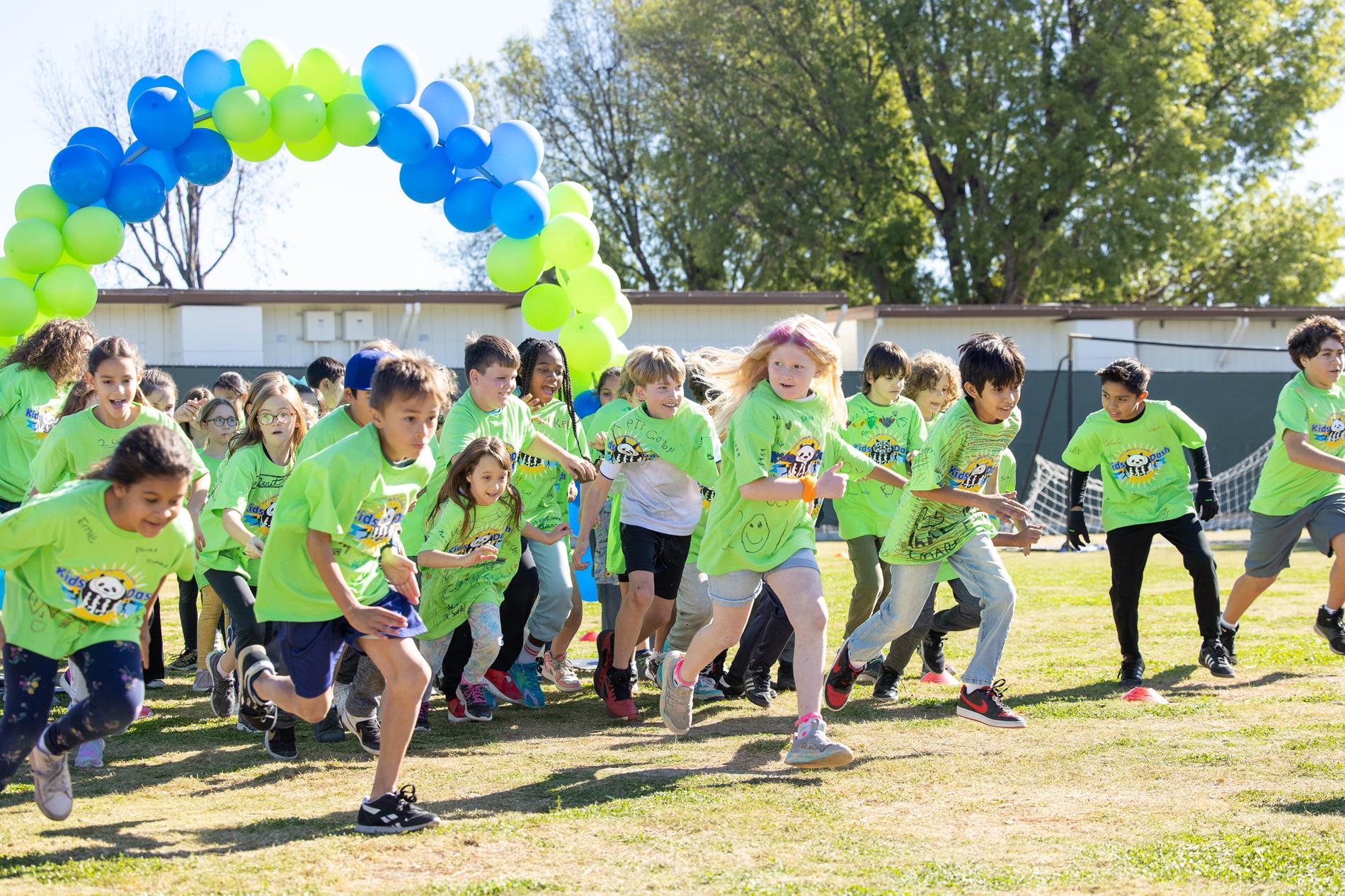 Children running and smiling on a field.