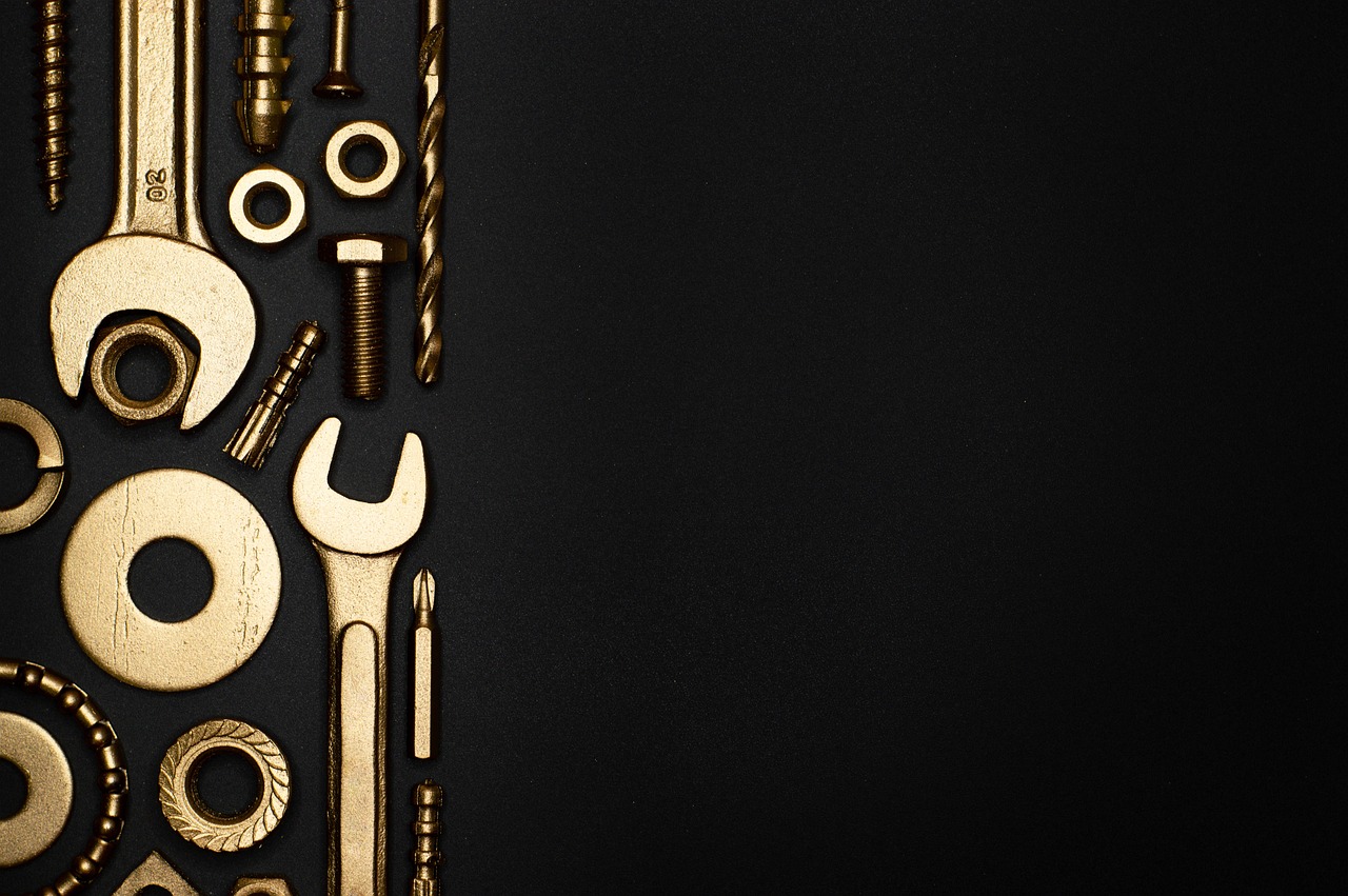 Wrenches, screws, and drill bits lay against a black background