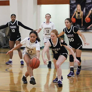 LHHS Girls basketball player dribbles the ball with a defender close by