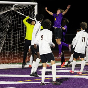 LHHS Boys soccer player head butts the ball at the goal