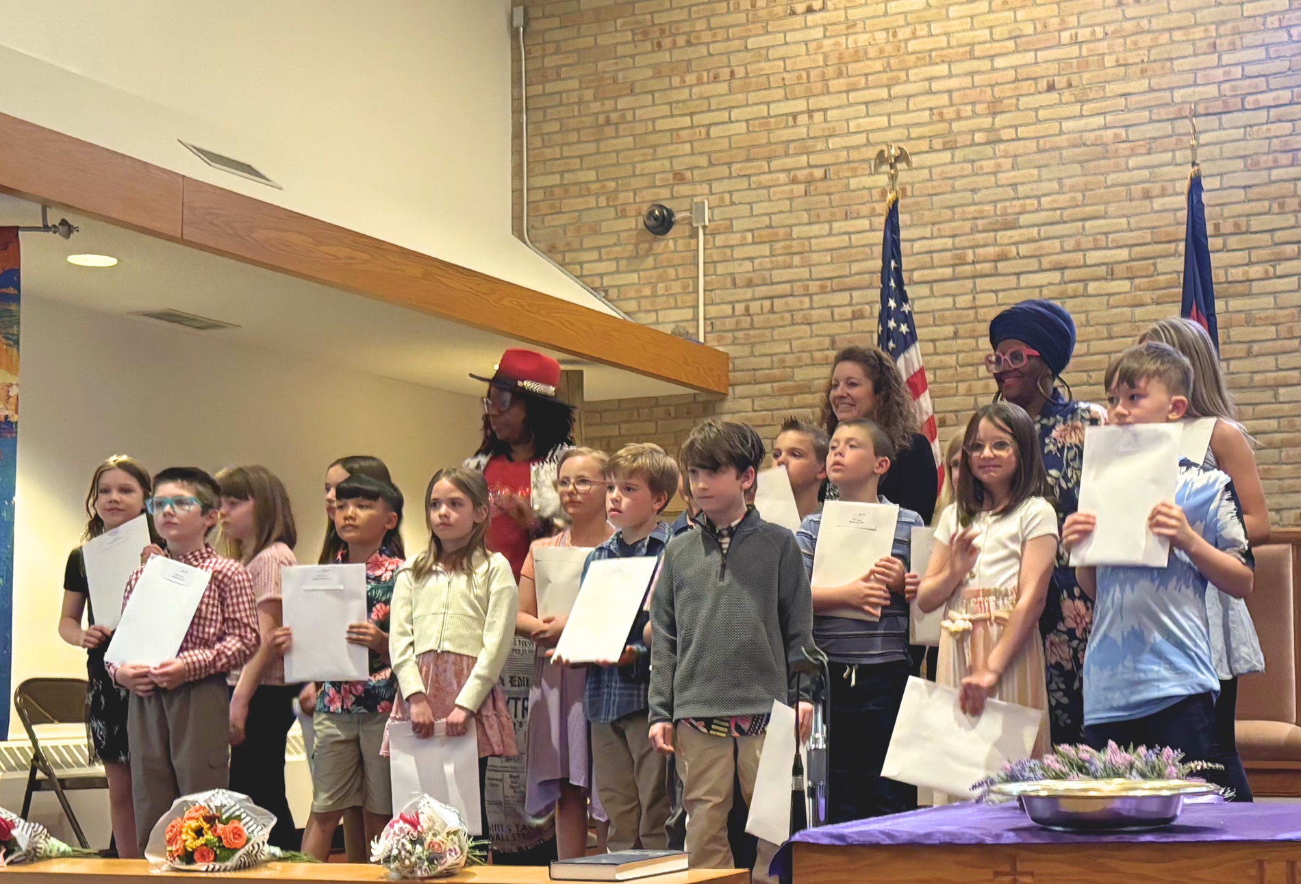 Students receiving 2026 CARE Awards stand with hosts Jacqueline Leapheart and Erin Patrice