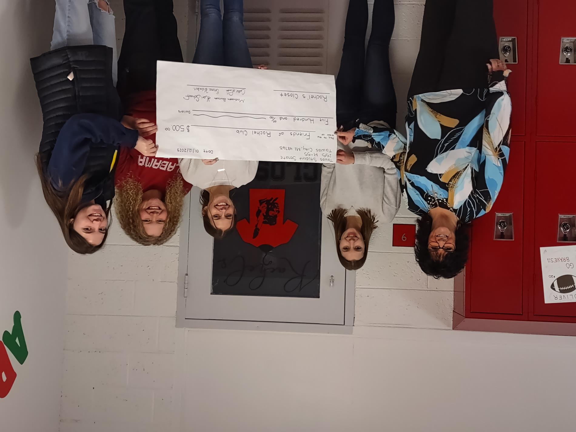 kids giving Mrs. Mochty a check