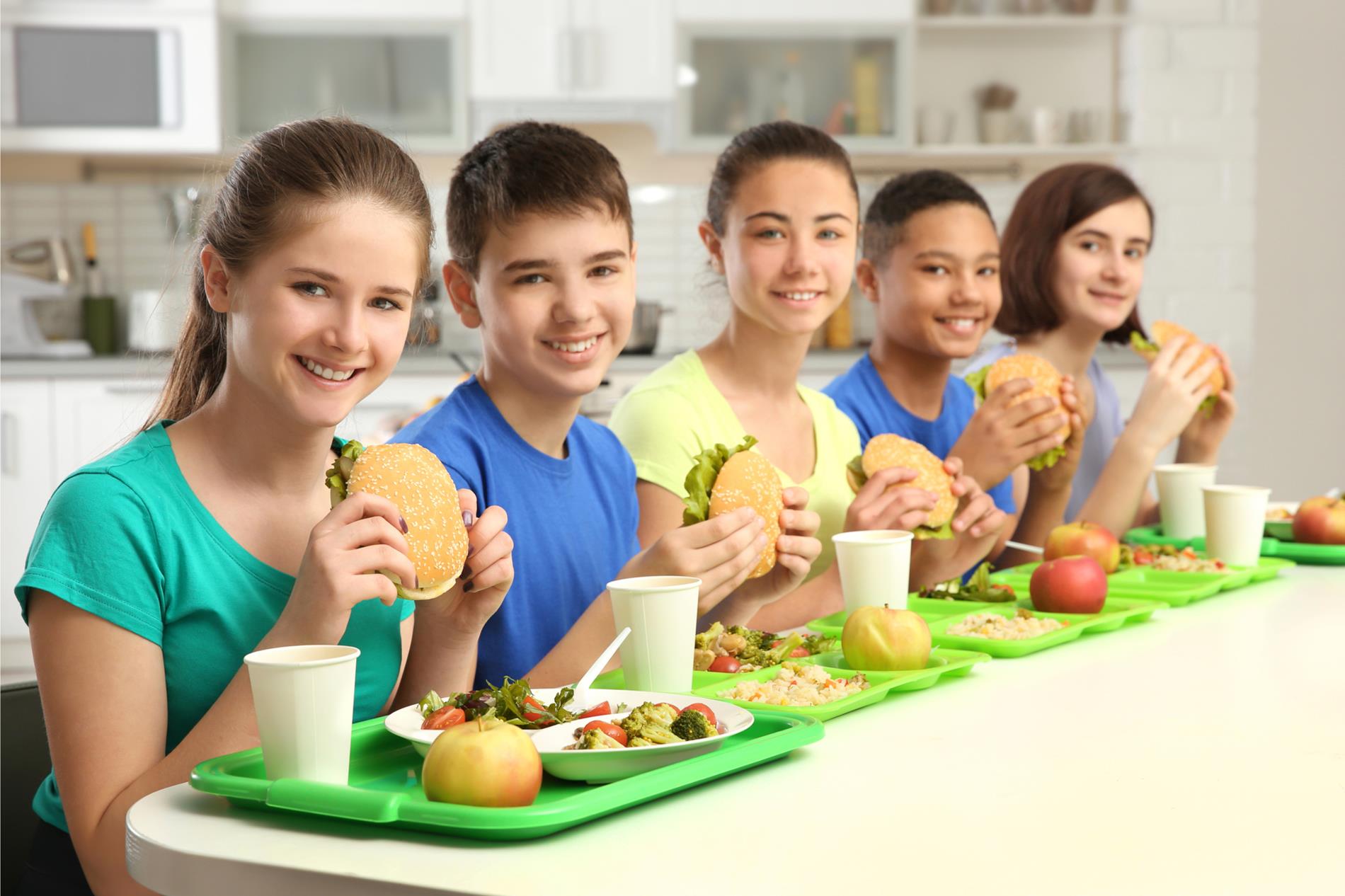 smiling students eating school lunch