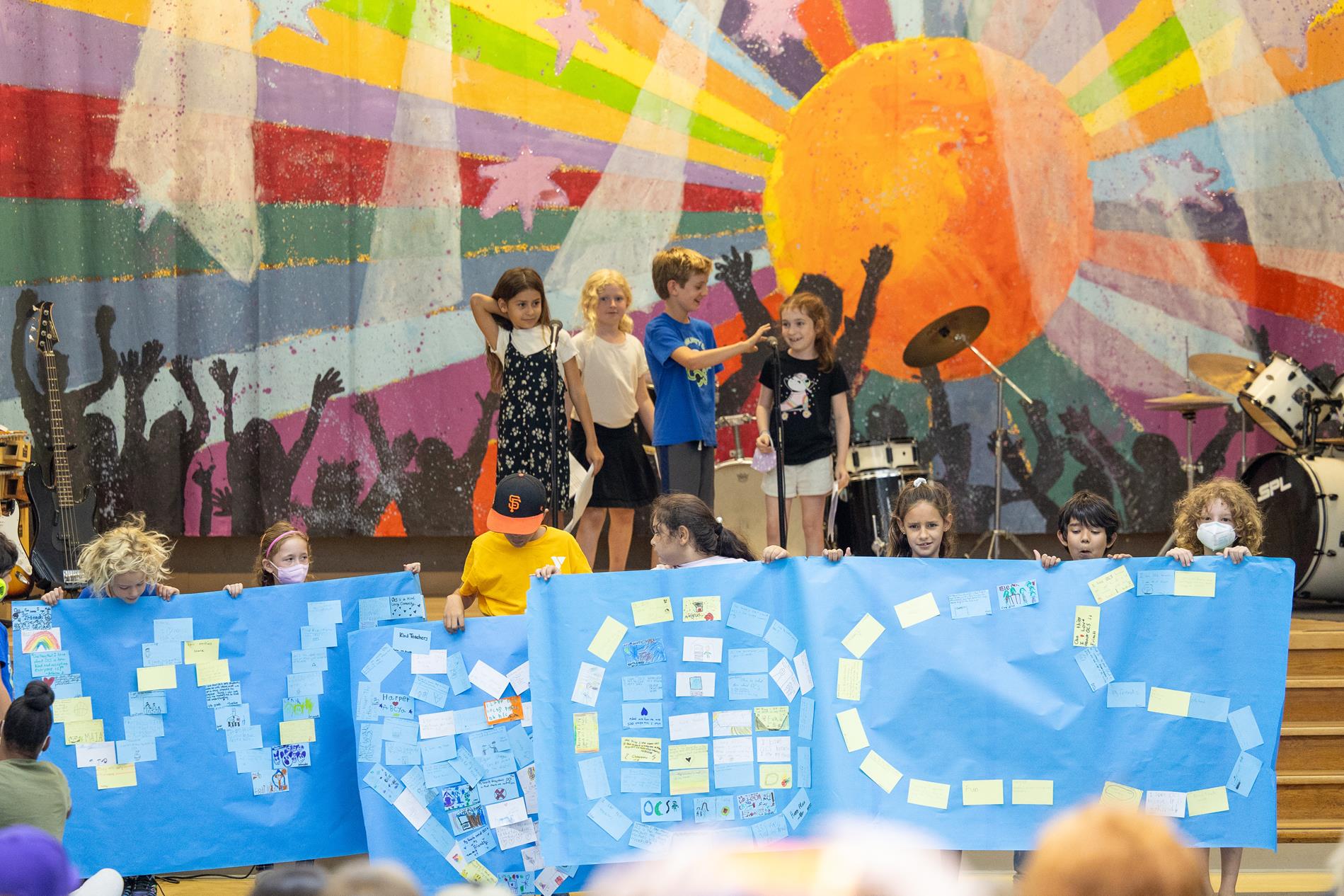 Children standing holding a we love OCS sign