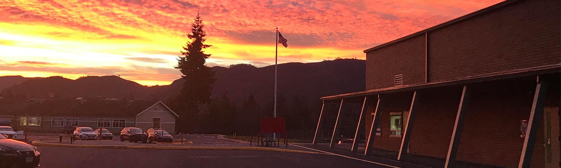 Sunset over the District Office parking lot, with flag