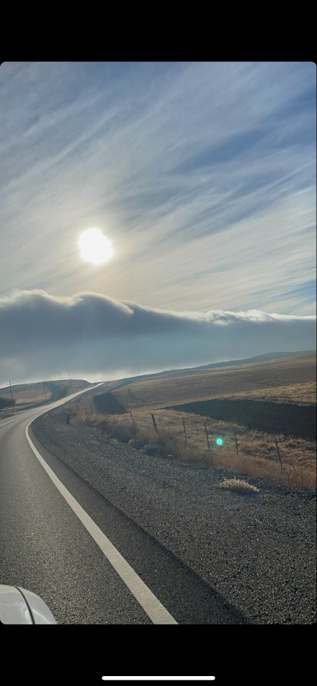 Photo By: Christina Blake March 17, 2022 - a photo taken from a car of a storm front moving through the sky just before it hides the sun
