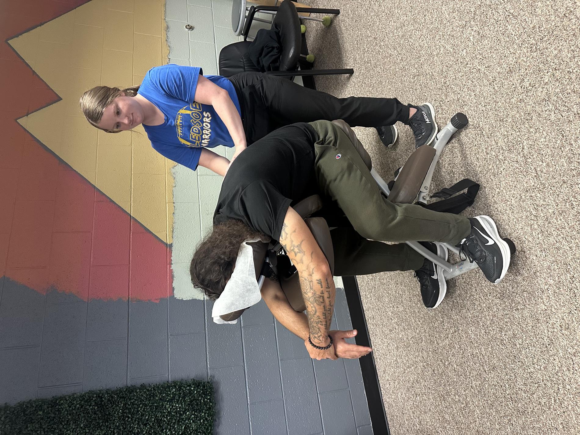 Staff being treated with 10-minute chair massages after a long work week. 