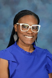 Teacher smiling against a blue background