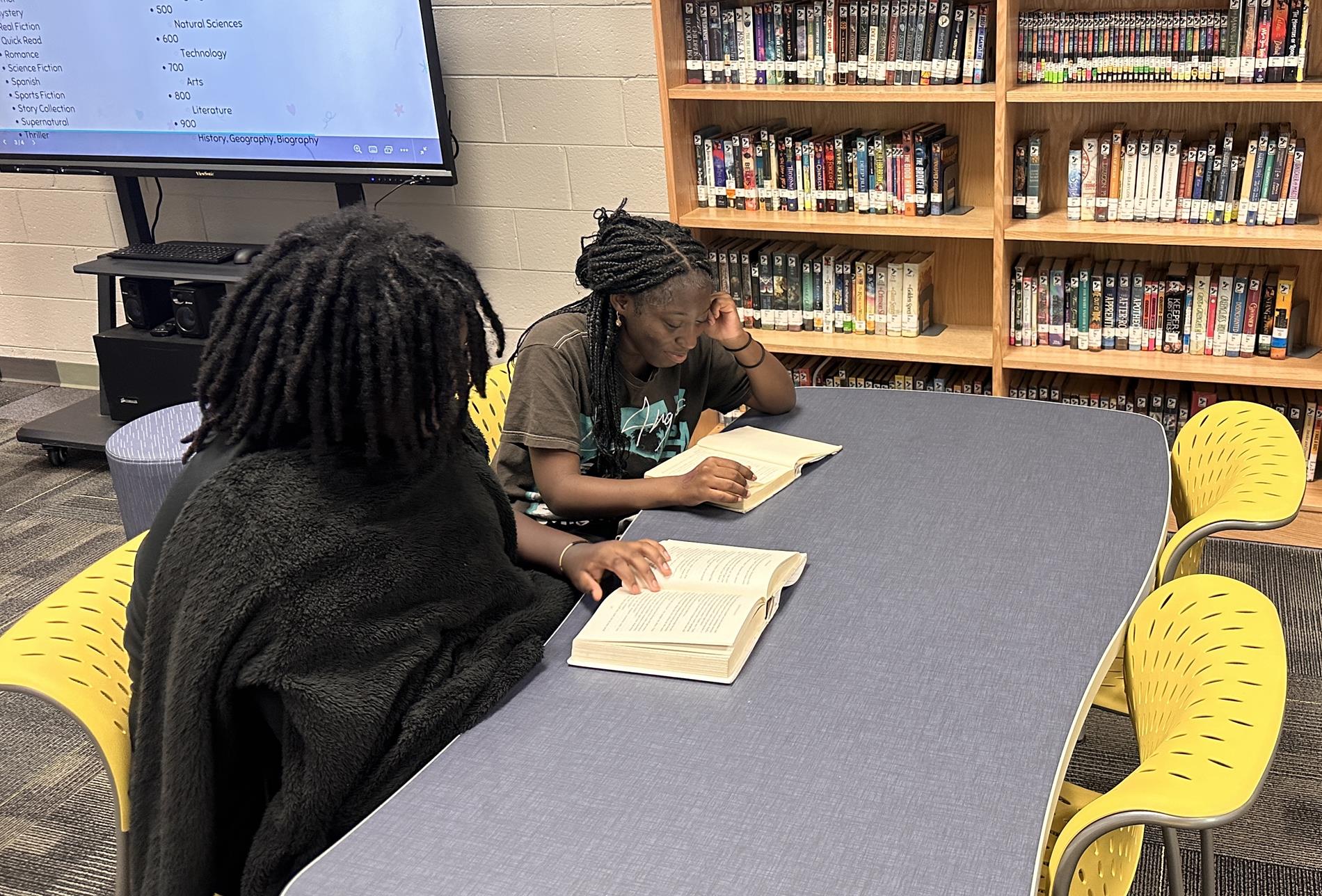 Students reading books in the media center.