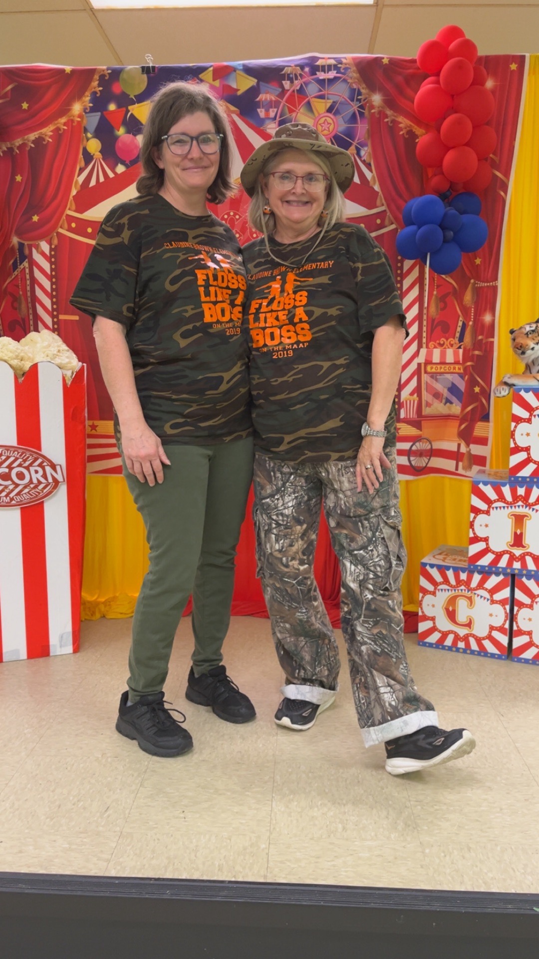 2 teachers with matching clothes on smiling.