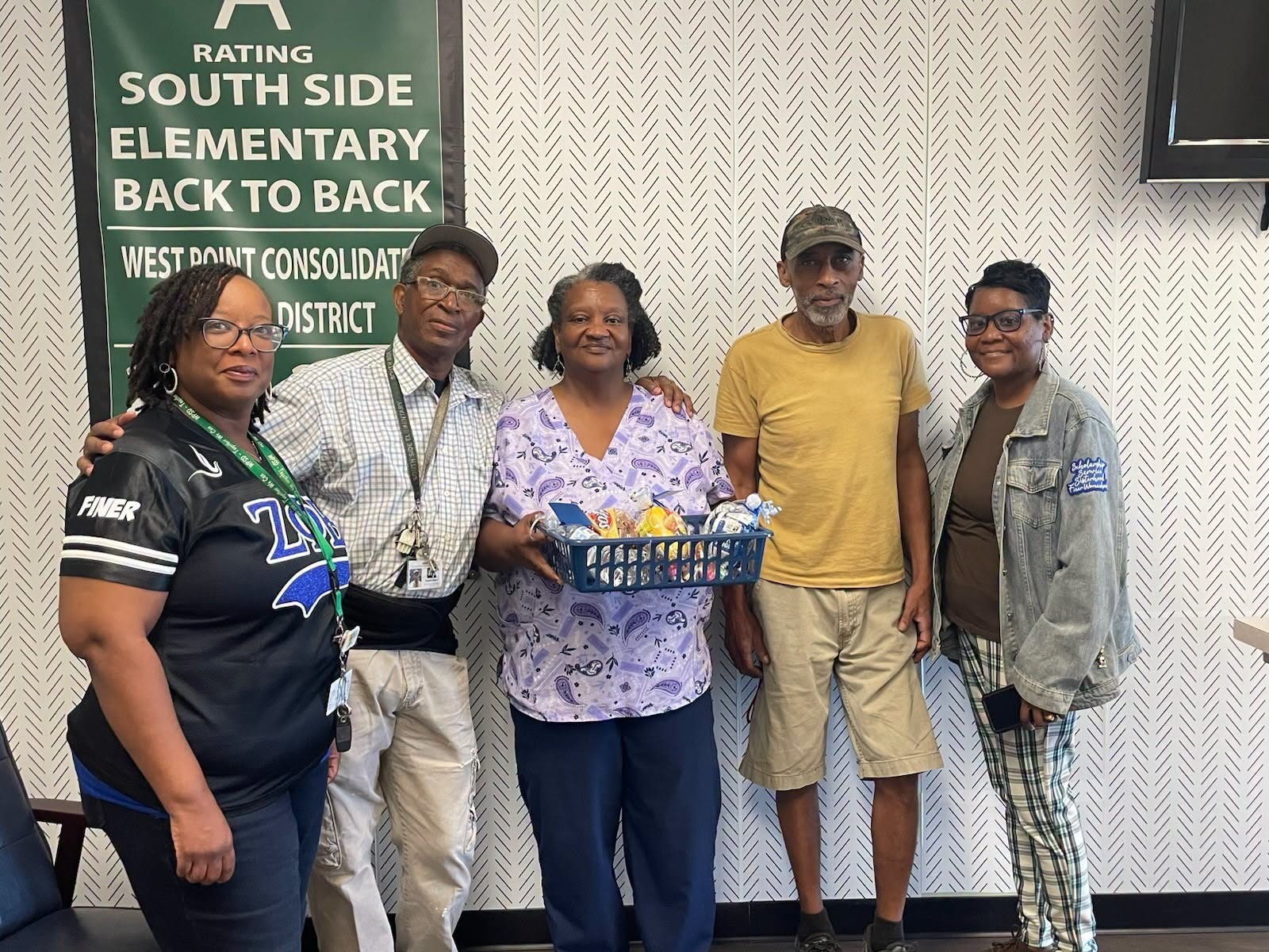 South Side Elementary custodial staff and community partners pose with an appreciation basket donated for Custodian Appreciation Day.