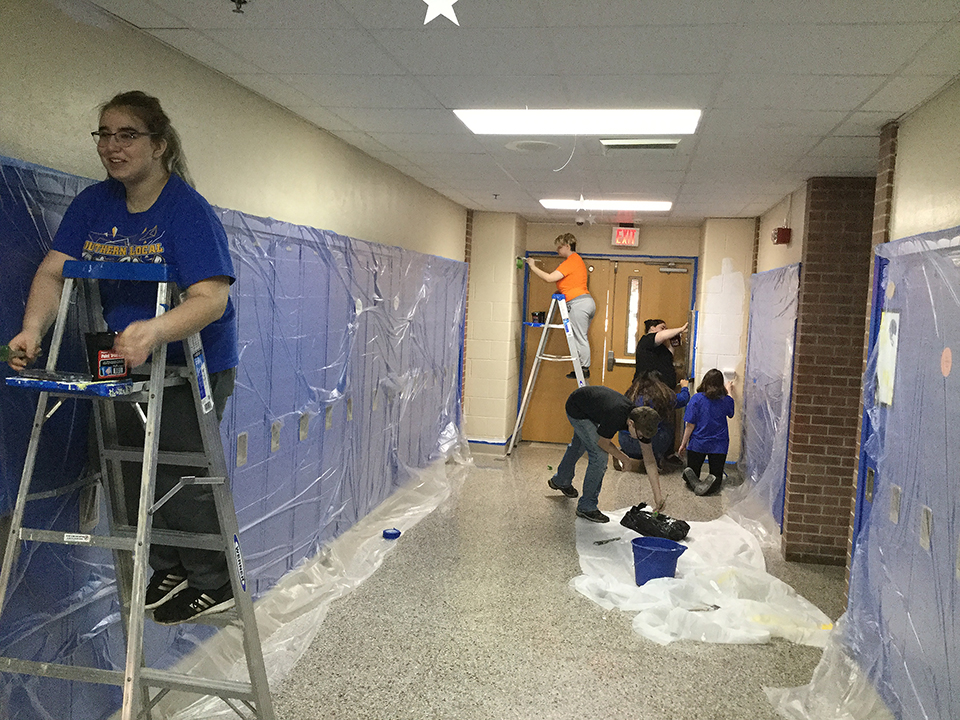 Students volunteering to help paint