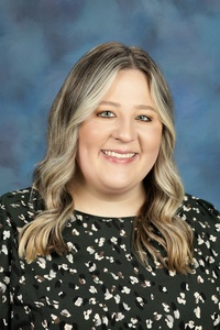 Teacher smiling against a blue background